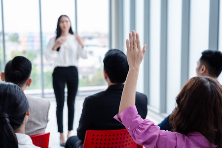 Business person raising hand during seminar. Hand up in conference asking to answer a question in business meeting room and seminar class.の写真素材