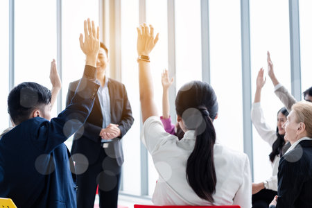 Business person raising hand during seminar. Hand up in conference asking to answer a question in business meeting room and seminar class.の写真素材