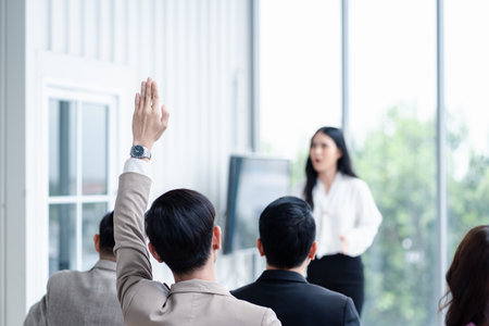 Business person raising hand during seminar. Hand up in conference asking to answer a question in business meeting room and seminar class.の写真素材