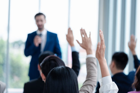 Business person raising hand during seminar. Hand up in conference asking to answer a question in business meeting room and seminar class.の写真素材