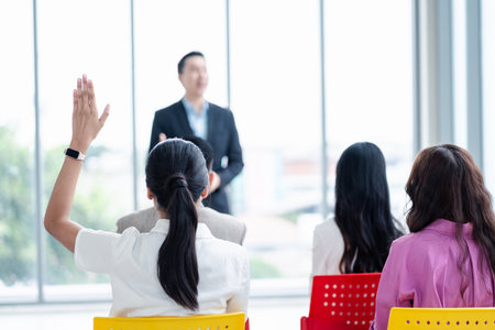 Business person raising hand during seminar. Hand up in conference asking to answer a question in business meeting room and seminar class.の写真素材