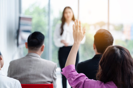 Business person raising hand during seminar. Hand up in conference asking to answer a question in business meeting room and seminar class.の写真素材