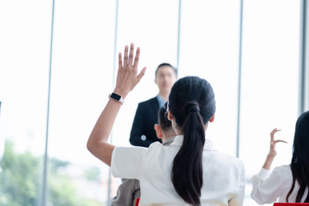 Business person raising hand during seminar. Hand up in conference asking to answer a question in business meeting room and seminar class.の写真素材