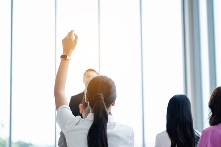 Business person raising hand during seminar. Hand up in conference asking to answer a question in business meeting room and seminar class.の写真素材