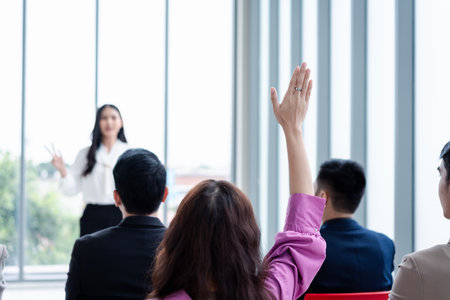 Business person raising hand during seminar. Hand up in conference asking to answer a question in business meeting room and seminar class.の写真素材