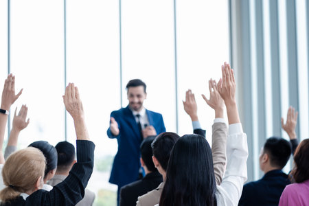 Business person raising hand during seminar. Hand up in conference asking to answer a question in business meeting room and seminar class.の写真素材