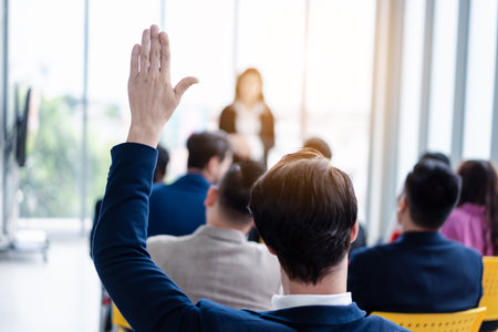Business person raising hand during seminar. Hand up in conference asking to answer a question in business meeting room and seminar class.の写真素材
