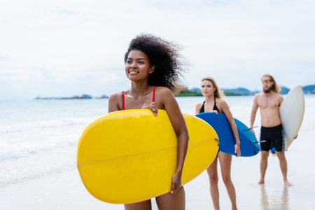 Group Friendship playing surfboard on the beach in weekend activity, Sport extreme healthy lifestyle concept.の写真素材