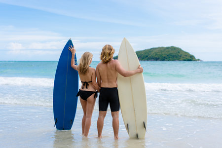 Couple playing surfboard on the beach in weekend activity, Sport extreme healthy lifestyle concept.の写真素材