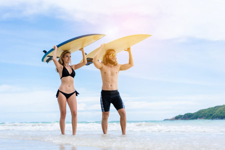 Couple playing surfboard on the beach in weekend activity, Sport extreme healthy lifestyle concept.の写真素材