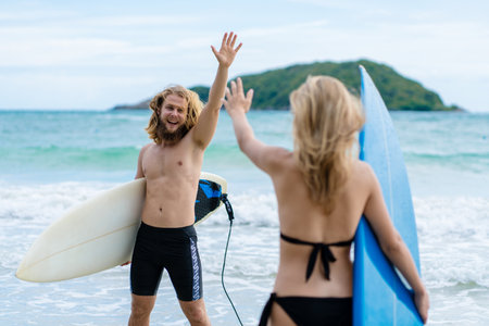 Couple playing surfboard on the beach in weekend activity, Sport extreme healthy lifestyle concept.の写真素材