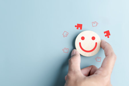 Hands holding blue happy smile face with jigsaw icon. mental health positive solution and growth mindset, mental health care recovery to happiness emotion.の写真素材