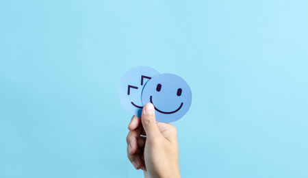 Hands holding happy smile face. mental health positive thinking and growth mindset, mental health care recovery to happiness emotion.の写真素材
