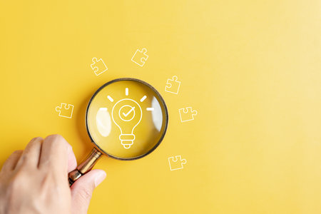 Magnifier glass focus to idea creative light bulb with jigsaw. planning development leadership and customer target group conceptの写真素材