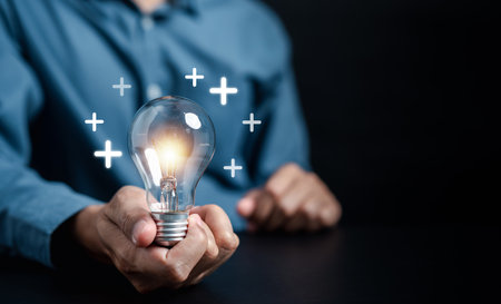 Hand man holding light bulb with plus sign, idea, innovation and inspiration, smart business intelligence creativity with bulbs, Motivation and innovation concept.の写真素材
