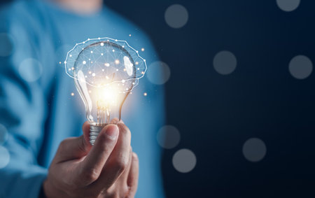 Hand man holding illuminated lightbulb, idea, innovation and inspiration with glowing virtual brain, smart intelligent creativity with bulbs, Motivation and innovation conceptの写真素材