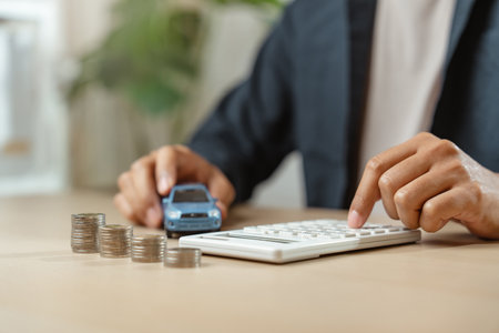 Man with car insurance coin stack. Buying or selling new vehicle. Ownership for new car or rent concept.の写真素材