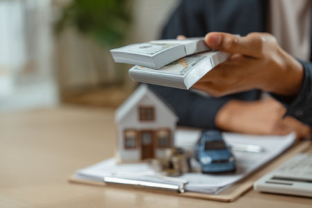 Insurance financial agent signing services to promote and sell insurance and car. man agent insurance calculate money for deals in buy or sell house and car.の写真素材
