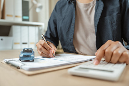 Man signing car insurance on paperwork assurance. Buying or selling new vehicle. Ownership for new car or rent concept.の写真素材