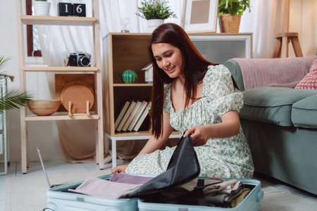 Woman Preparation Suitcase Packing Vacation Journey Tourist Luggage Young Female Traveler Carefully Packs Her Bag for a Relaxing Weekend Trip Full of Joyの写真素材