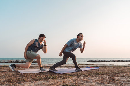 Men doing exercise together and sporty active outside sea beach