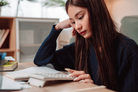 Student Studying and Doing Homework Woman Young University Female Reading Education Writing, Focused Young Adult Engaged in Learning and Academic Work at Home, Preparing for Successの写真素材