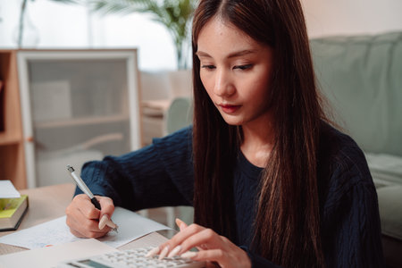 Student Studying and Doing Homework Woman Young University Female Reading Education Writing, Focused Young Adult Engaged in Learning and Academic Work at Home, Preparing for Successの写真素材