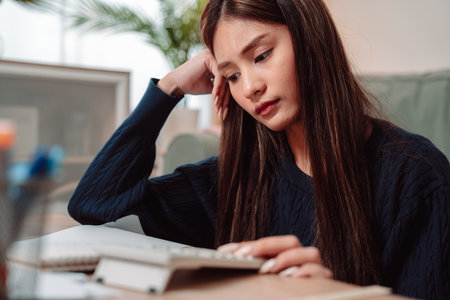 Student Studying and Doing Homework Woman Young University Female Reading Education Writing, Focused Young Adult Engaged in Learning and Academic Work at Home, Preparing for Successの写真素材