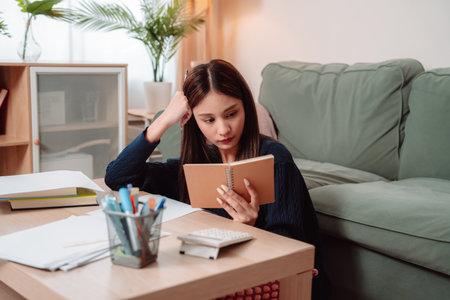 Student Studying and Doing Homework Woman Young University Female Reading Education Writing, Focused Young Adult Engaged in Learning and Academic Work at Home, Preparing for Successの写真素材
