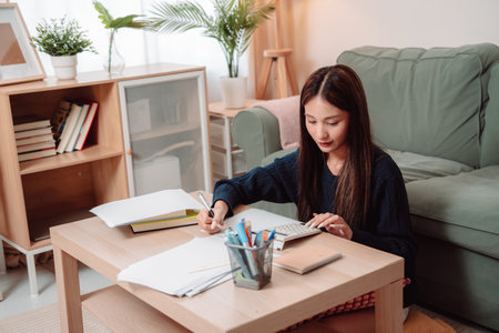 Student Studying and Doing Homework Woman Young University Female Reading Education Writing, Focused Young Adult Engaged in Learning and Academic Work at Home, Preparing for Successの写真素材
