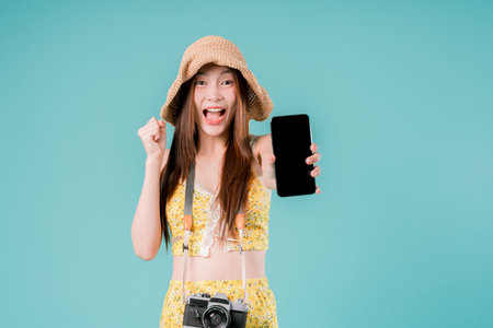 Asian Woman using smartphone for booking and buying ticket Online, Young Woman Holding a Mobile Phone Summer Vacation Concept on studio background.の写真素材
