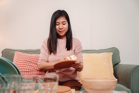 Asian Female Housework Dish Woman Cleaner Washer Hygiene Work Smile, Cheerful Young Woman Enjoys Her Daily Cleaning Routine at Home, Washing Dishes with Care and Dedication in a Bright Kitchenの写真素材