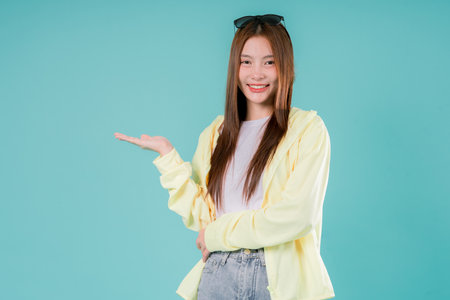 Woman Pointing Advertisement Excited Joyful Gesture Youth Teenage Positive, A Cheerful Young Lady in Casual Fashion Pointing Up with a Bright Smile On Studio Backgroundの写真素材