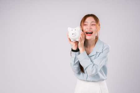 Woman Saving Money Save Bank Happy Finance Invest Profit Deposit, Young Woman Smiling Brightly While Saving and Investing Wisely, Celebrating Financial Growth and a Confident Step Toward Successの写真素材