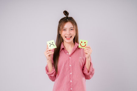 Smile happy face on hands of woman with massage between sad and normal emotion, Positive emotion, Mental health care concept.の写真素材