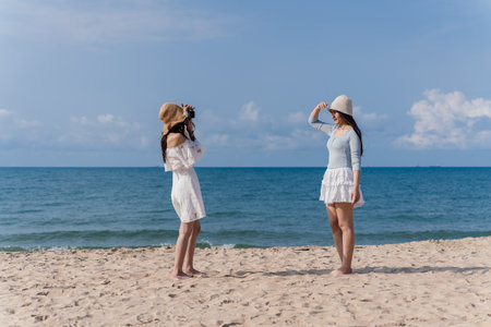 Woman Friendship Enjoyment Beach Seascape Lifestyle Camera Photography Females Smile, Young Women Joyful Moments Together on a Carefree Summer Vacation by the Seaの写真素材
