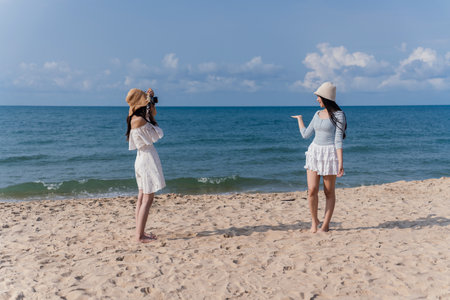 Woman Friendship Enjoyment Beach Seascape Lifestyle Camera Photography Females Smile, Young Women Joyful Moments Together on a Carefree Summer Vacation by the Seaの写真素材