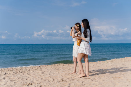 Woman Friendship Enjoyment Beach Seascape Lifestyle Camera Photography Females Smile, Young Women Joyful Moments Together on a Carefree Summer Vacation by the Seaの写真素材