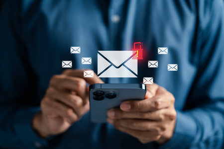 Email icon with virus and spam alert appearing on smartphone screen. Representing cybersecurity threats, phishing danger, malicious email detection, and digital communication security.の写真素材