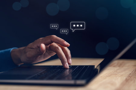 Typing on laptop keyboard with online chat representing chatbot communication, AI conversation, and real-time online messaging in digital platforms.の写真素材