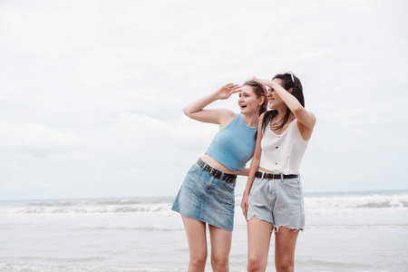Two young female friends on the beach, looking ahead and excitement. friendship, adventure, summer...