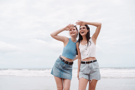 Two young female friends on the beach, looking ahead and excitement. friendship, adventure, summer...