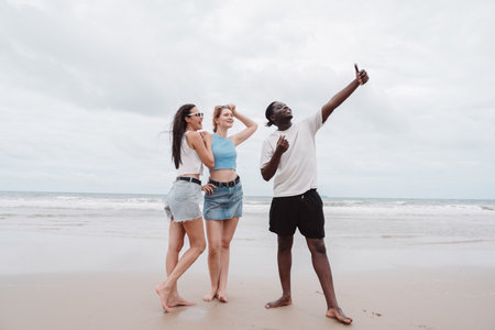 Diverse group of young friends taking selfie and enjoying time together on the beach. Fun summer...
