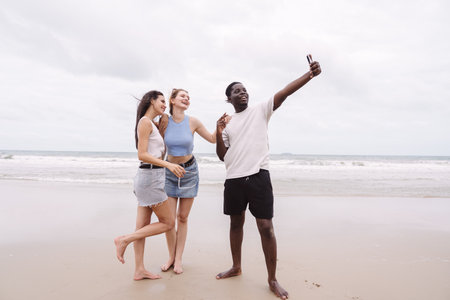 Diverse group of young friends taking selfie and enjoying time together on the beach. Fun summer...