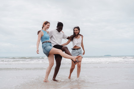 Diverse group of friends walking the beach, enjoying freedom and fun in summer vacation. happiness, and multicultural friendshipの写真素材