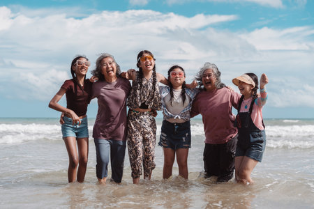 Relaxed Asian family with senior women and children enjoying time together at the beach. Celebrating...
