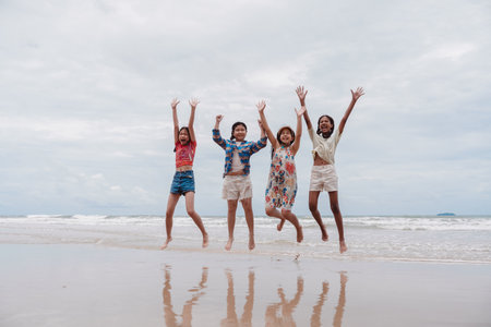 Friends jumping at the beach with joyful energy. Asian and multicultural little girls having fun...