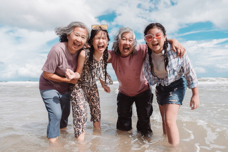 Happy Asian family generations laughing on the beach. elderly women, daughter, and a kid embracing...