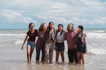 Relaxed Asian family with senior women and children enjoying time together at the beach. Celebrating...