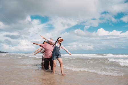 Asian family enjoying retirement wellness the beach, walking joyful moment balance, health, freedom, and intergenerational bonding.の写真素材